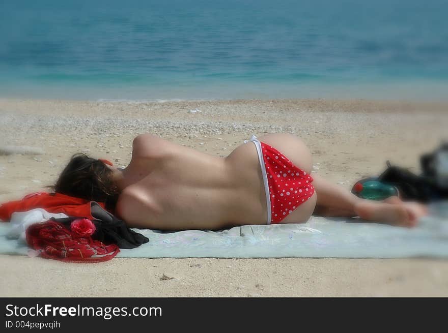 Topless babe takes a nap on the beach