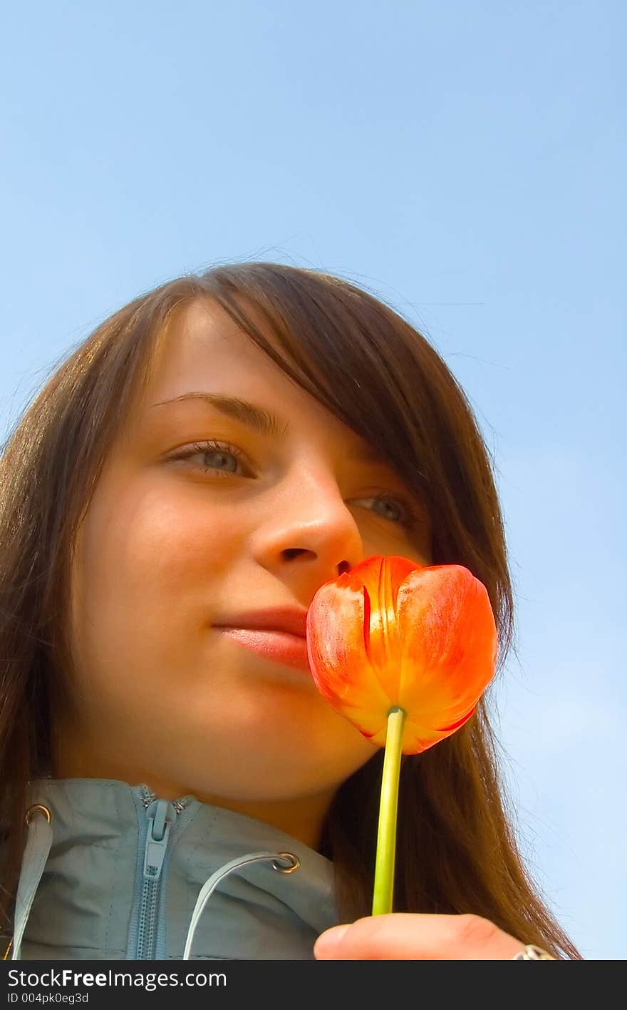 The girl with a flower on a background of the sky