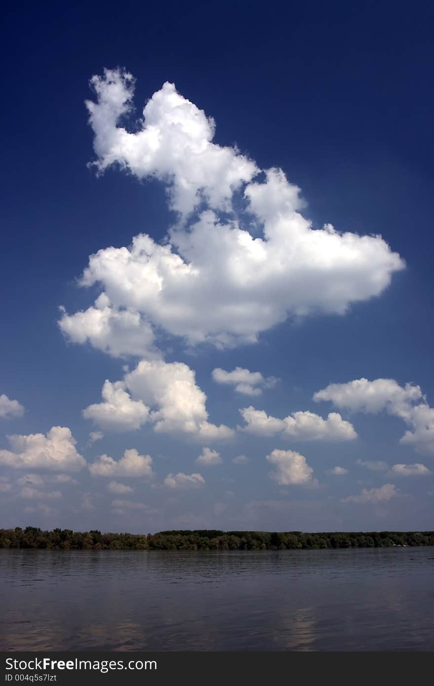 Riverscape with blue sky and white clouds