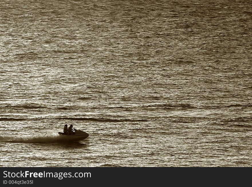 Silhouete of a wave runner on sunset(sepia)