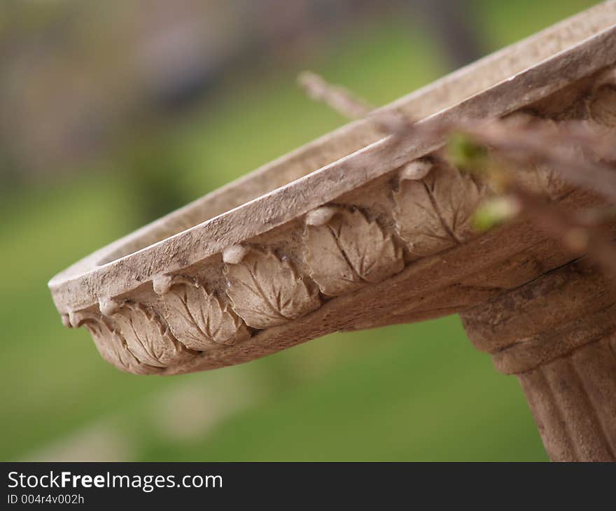 An antique terra cotta birdbath with leaf patterns. An antique terra cotta birdbath with leaf patterns