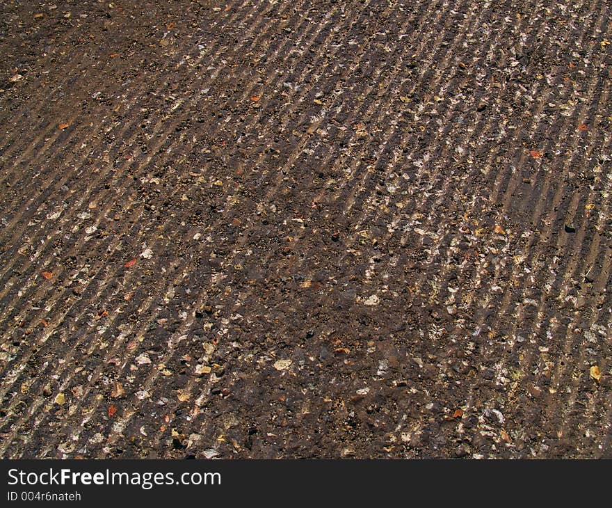 Tread grooves cut into road ashalt on an urban street.