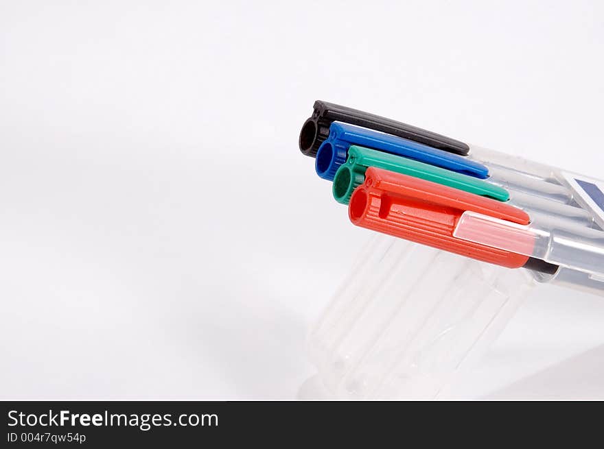 A set of four different colored markers in holder. A set of four different colored markers in holder