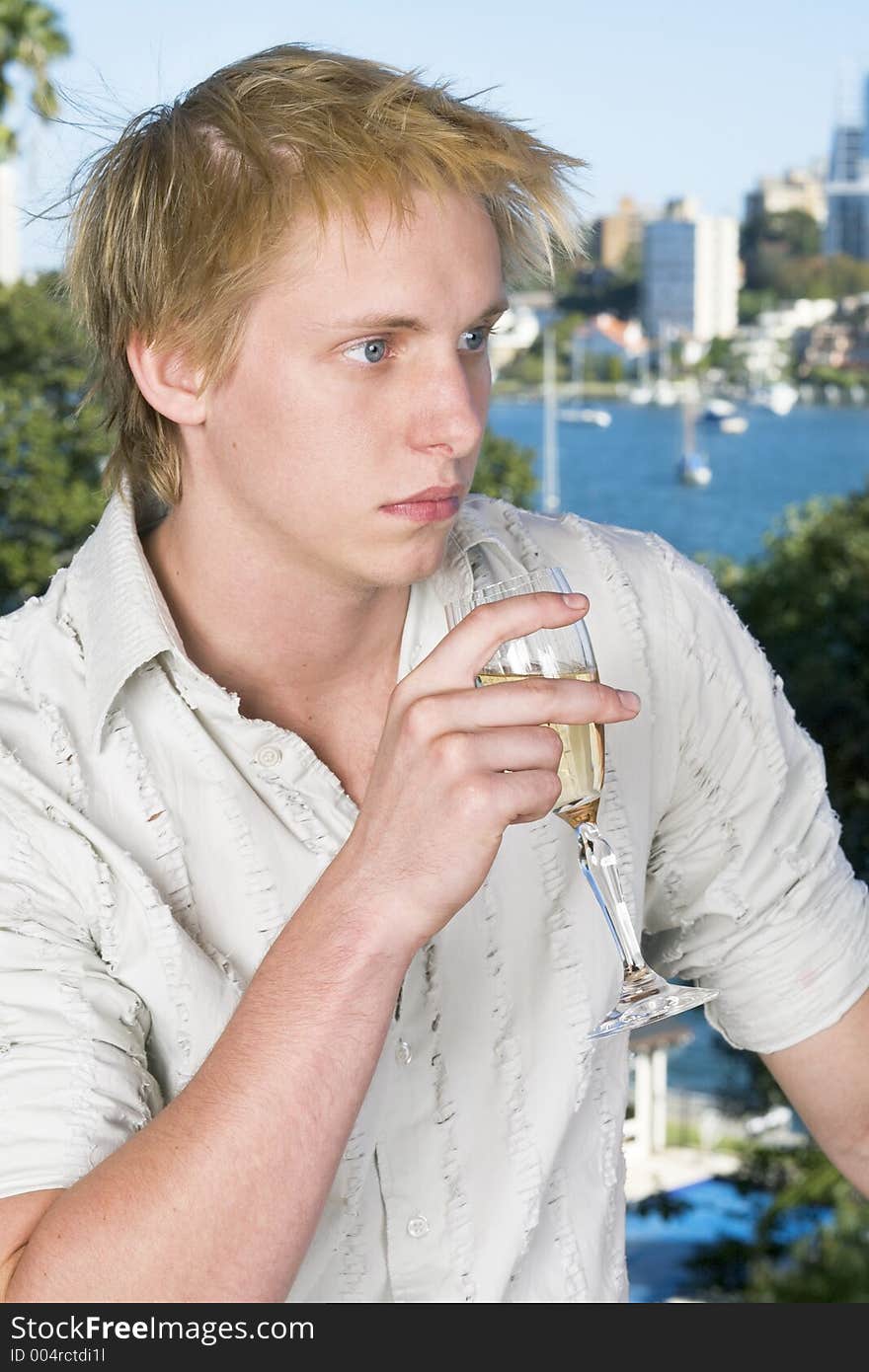 Young man drinking champagne on the balcony