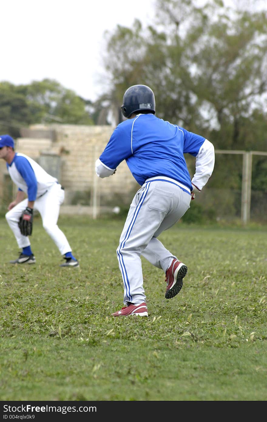 Action during a baseball game. Batter runs for base. Action during a baseball game. Batter runs for base.