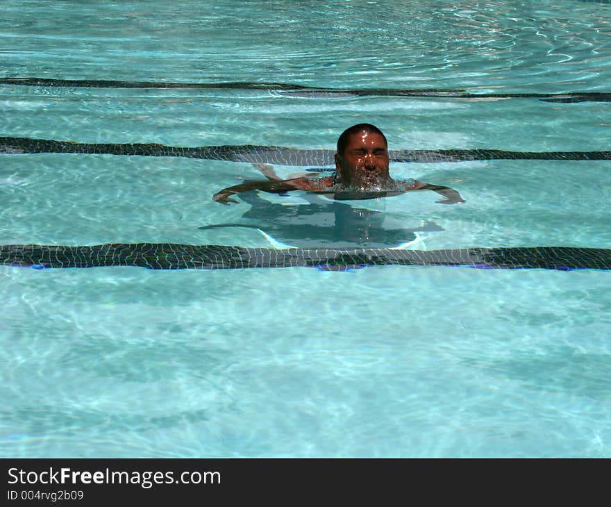 Man at the pool coming out of the water. Man at the pool coming out of the water