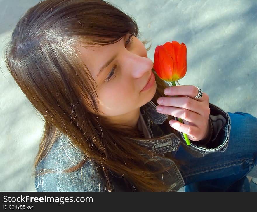 The girl with a flower on a background of asphalt. The girl with a flower on a background of asphalt