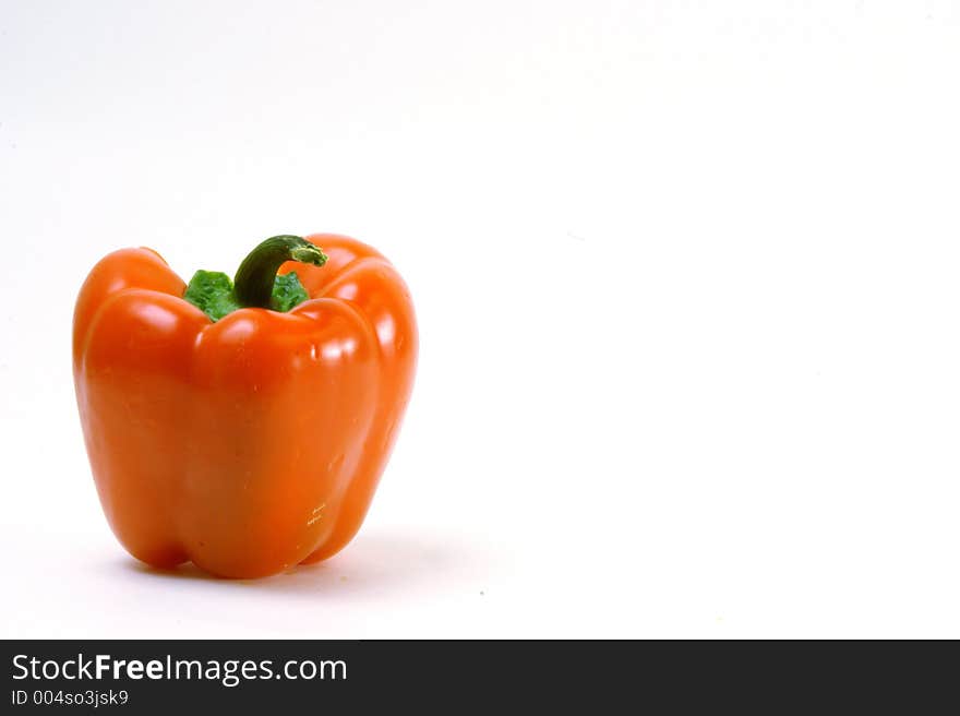 Colorful orange capsicum in front of a white background. Colorful orange capsicum in front of a white background