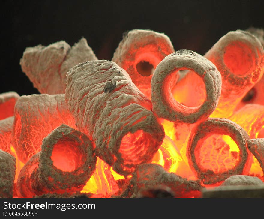 A closeup shot of burning hot cylinder shaped charcoal. A closeup shot of burning hot cylinder shaped charcoal