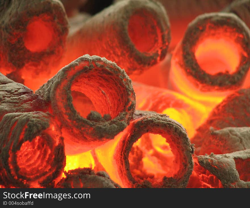 A closeup shot of burning hot cylinder shaped charcoal. A closeup shot of burning hot cylinder shaped charcoal