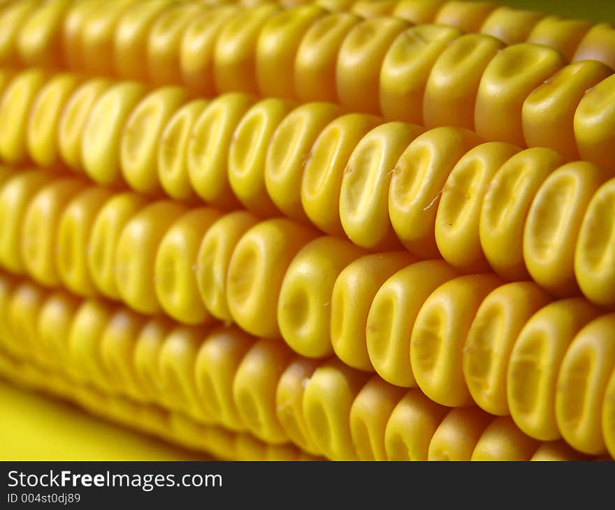 Golder corn close up on yellow background. Golder corn close up on yellow background