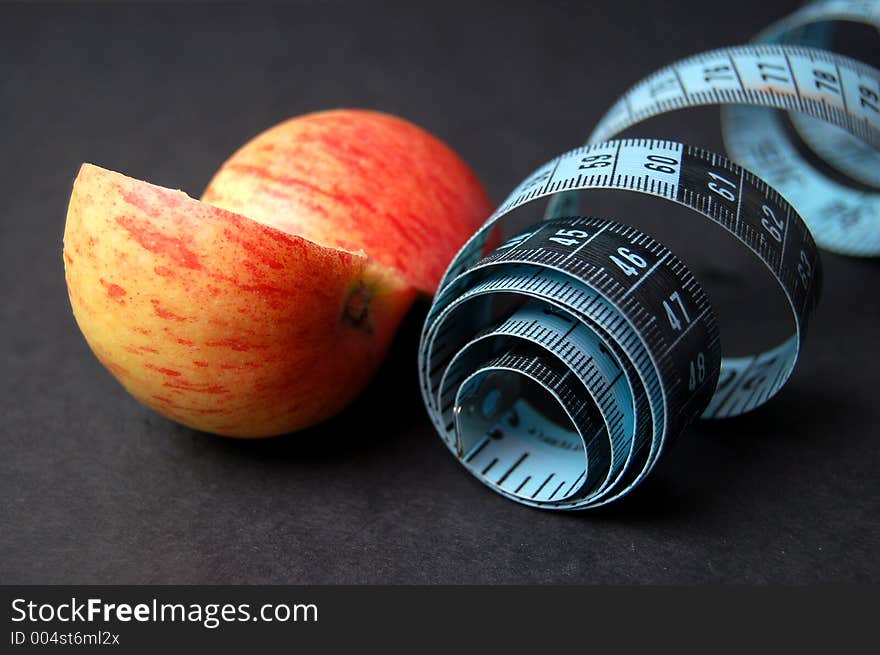 This is an image of a measuring tape and a sliced apple. (Please let me know where the image will be used by leaving a message in the Comments Section/See Portfolio). This is an image of a measuring tape and a sliced apple. (Please let me know where the image will be used by leaving a message in the Comments Section/See Portfolio)