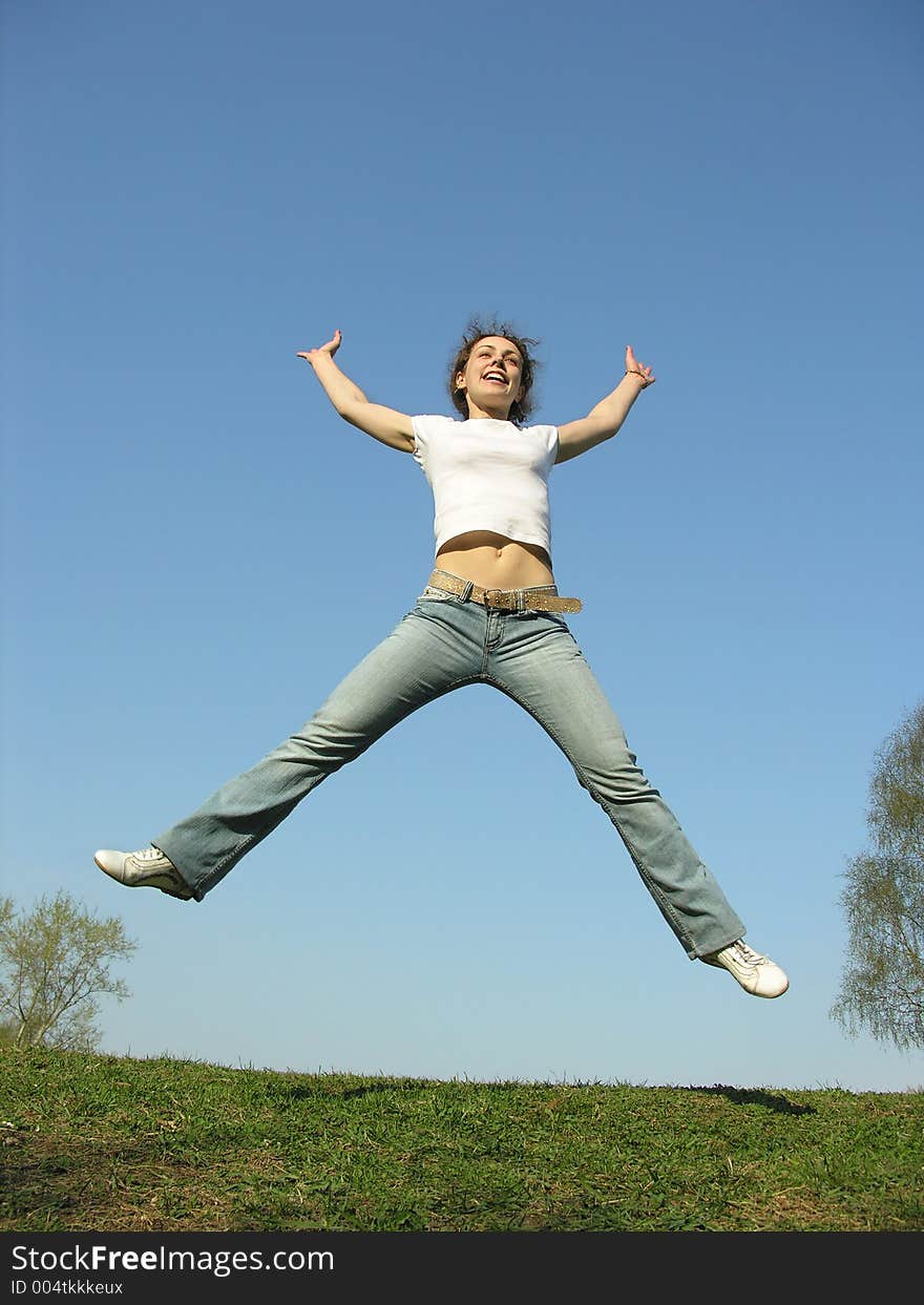 Jump girl on meadow. blue sky