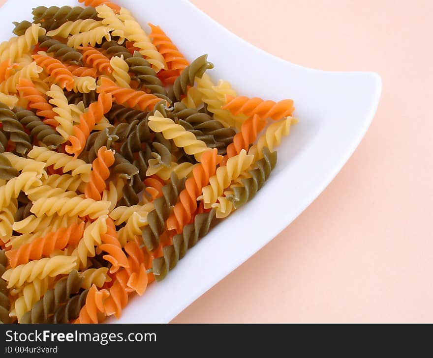 Three colors of pasta on a white plate