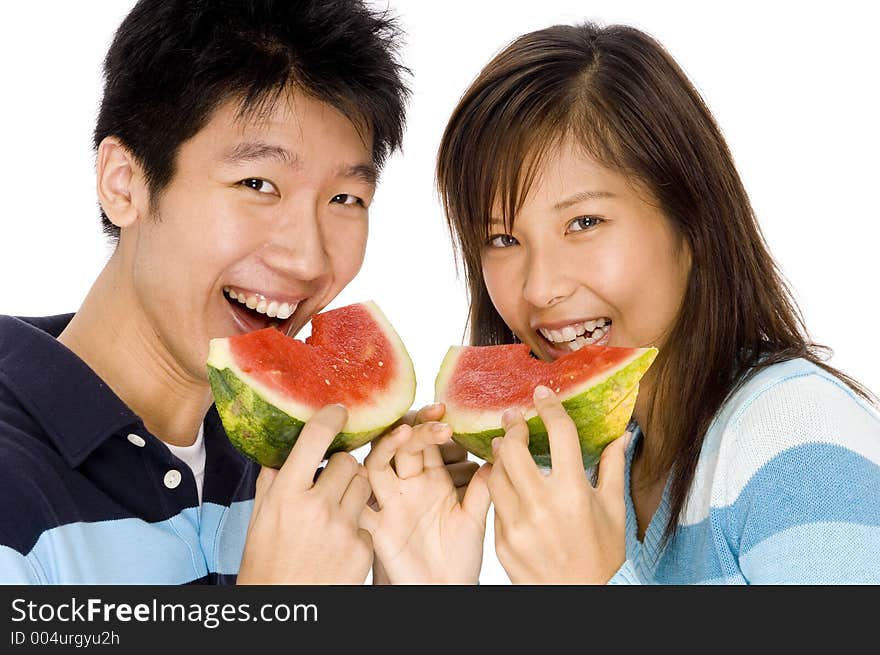 A young couple enjoying eating watermelon. A young couple enjoying eating watermelon