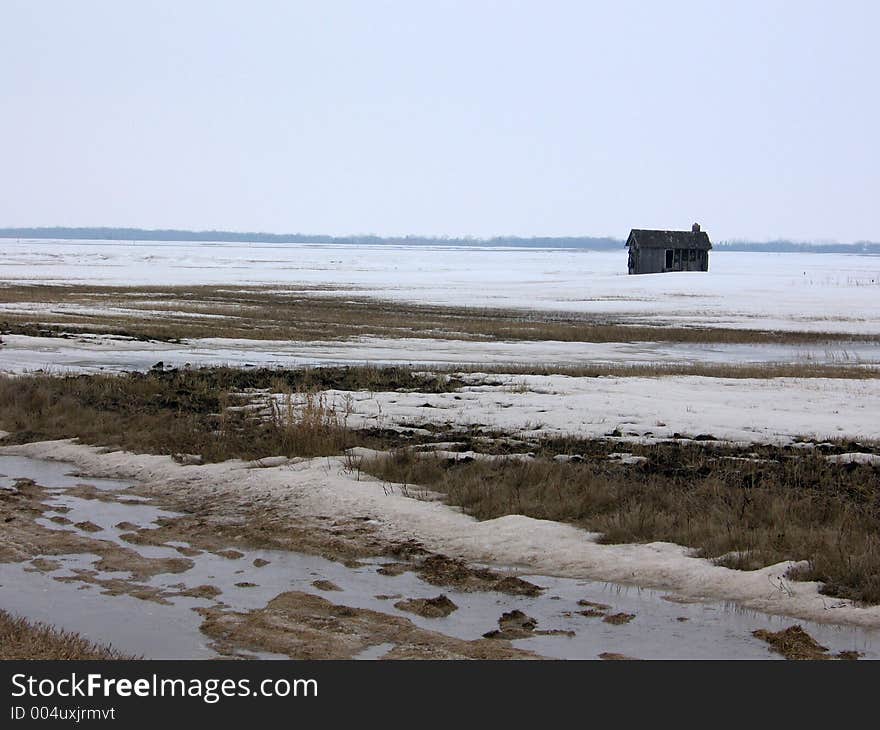 This image depicts a field in the winter with an old, abandoned shack in it. This image depicts a field in the winter with an old, abandoned shack in it.