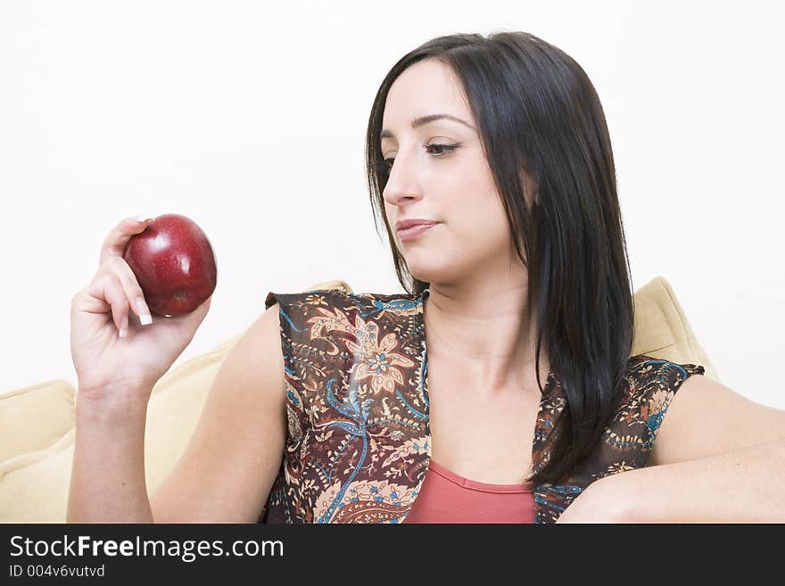 Brunette looking at a red apple