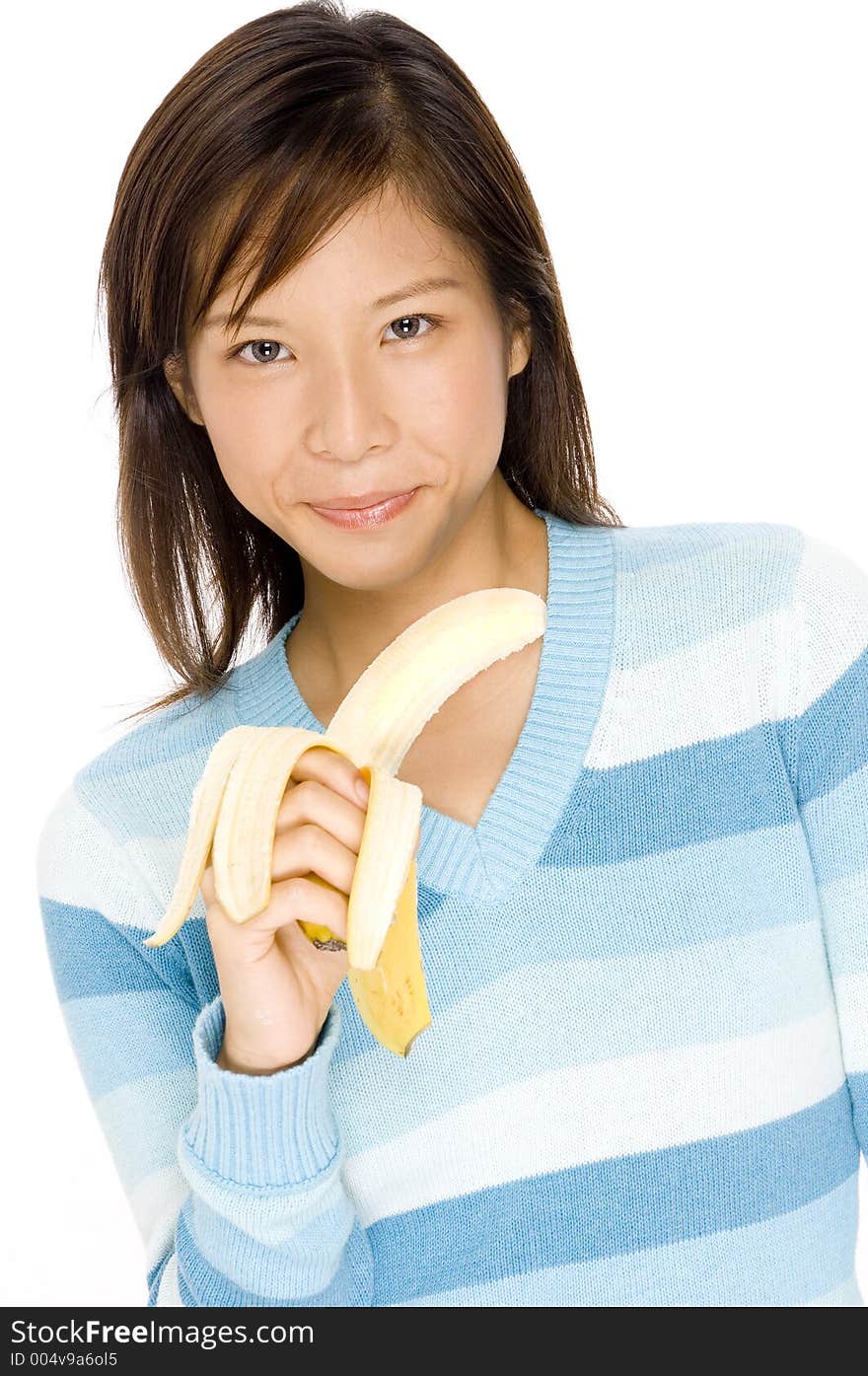 A cute young asian woman with a peeled banana. A cute young asian woman with a peeled banana