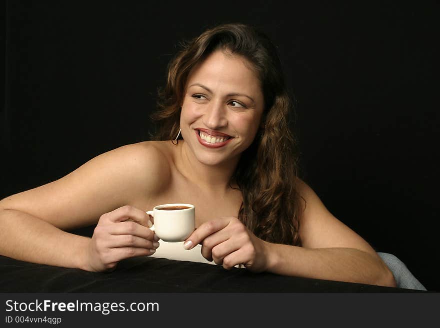 Beautiful brunette Brazilian woman smiling holds a cup of hot chocolate or coffee. Beautiful brunette Brazilian woman smiling holds a cup of hot chocolate or coffee