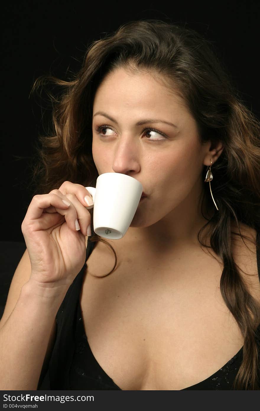 Beautiful brunette Brazilian woman sips a cup of hot chocolate or coffee. Beautiful brunette Brazilian woman sips a cup of hot chocolate or coffee