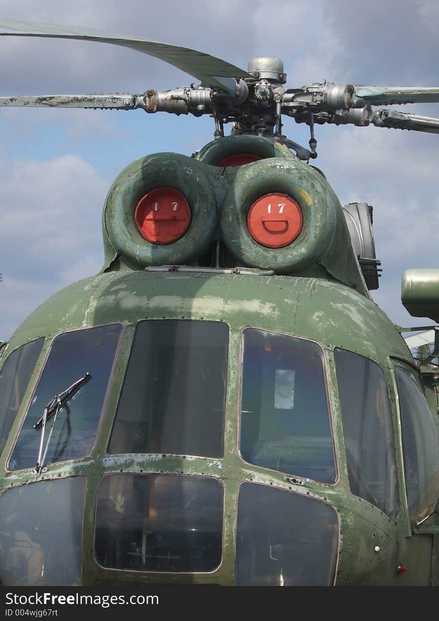 Closeup image of an abandoned helicopter with a chip paint texture and a cloudy sky in the background. Closeup image of an abandoned helicopter with a chip paint texture and a cloudy sky in the background