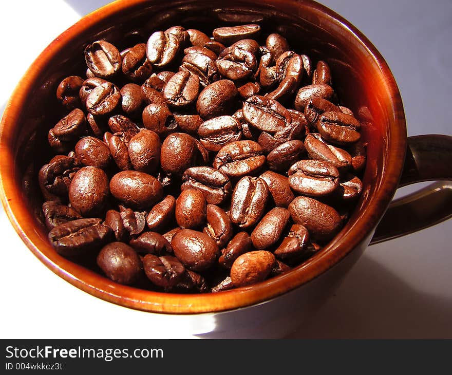 Coffee beans in a mug in the sun