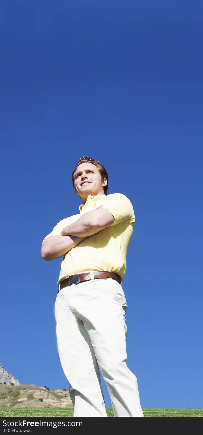 Young man smiles under a blue sky