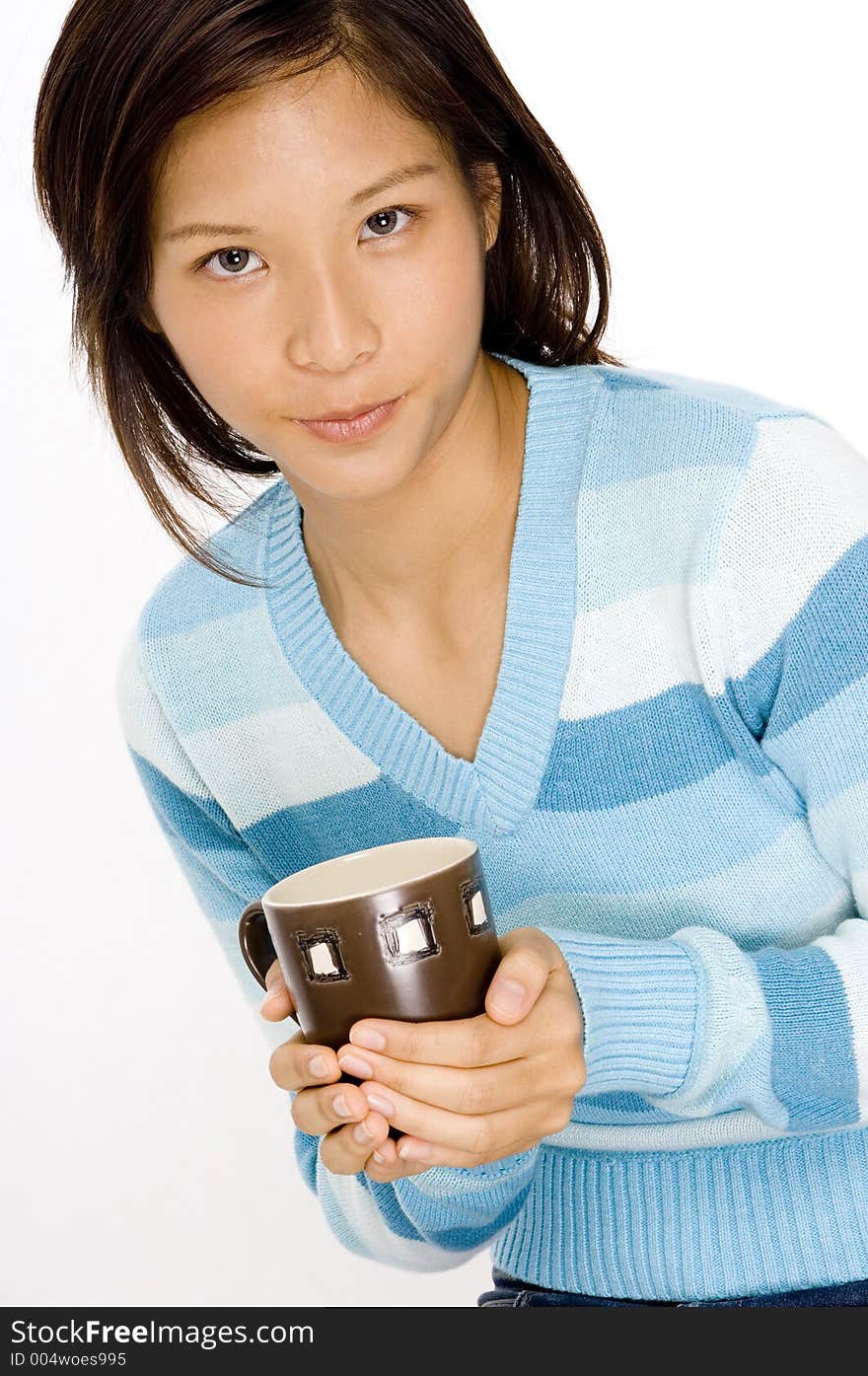 A pretty young asian woman holding a brown mug. A pretty young asian woman holding a brown mug