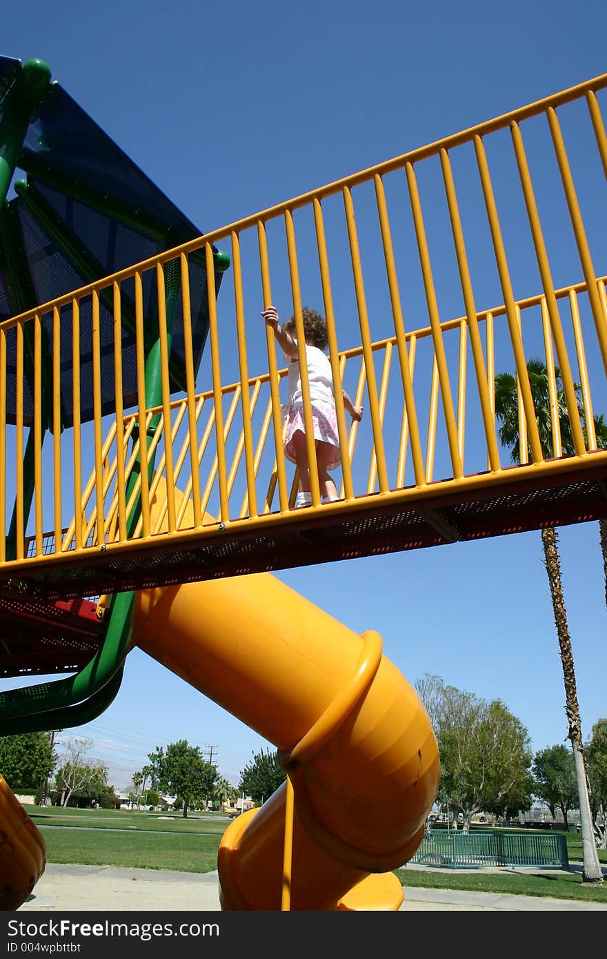 Little girl running through playground bridge. Little girl running through playground bridge