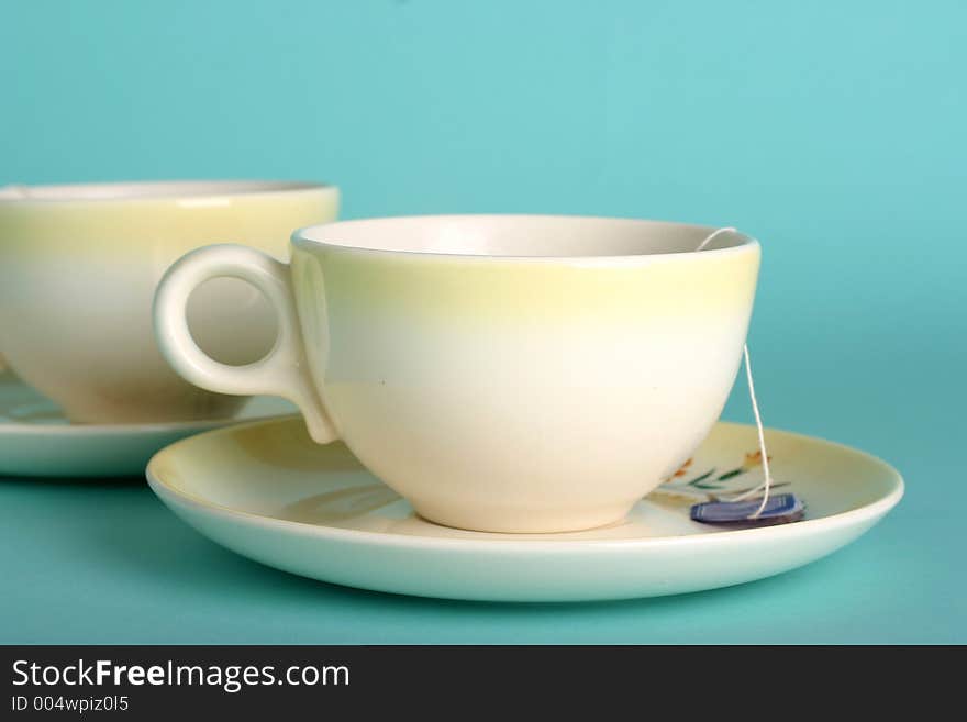 Two vintage yellow teacups with teabag; fresh color scheme. Two vintage yellow teacups with teabag; fresh color scheme