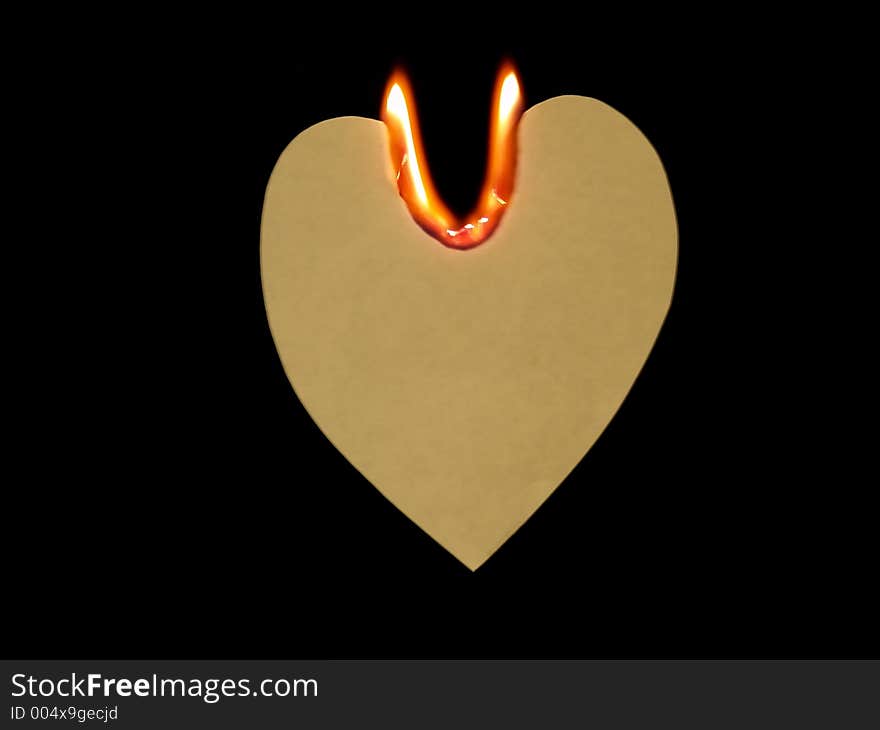 High-resolution digital photo of handcrafted grunge paper heart on fire with U-shaped flame means Love You (suspending in the air with black background)