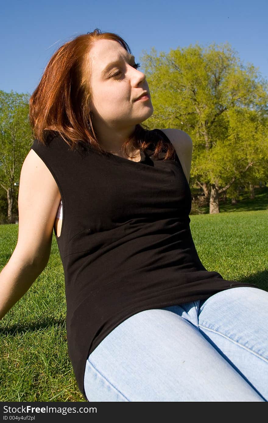 An attractive young lady gazes onward during a warm, summer day in the park. An attractive young lady gazes onward during a warm, summer day in the park.