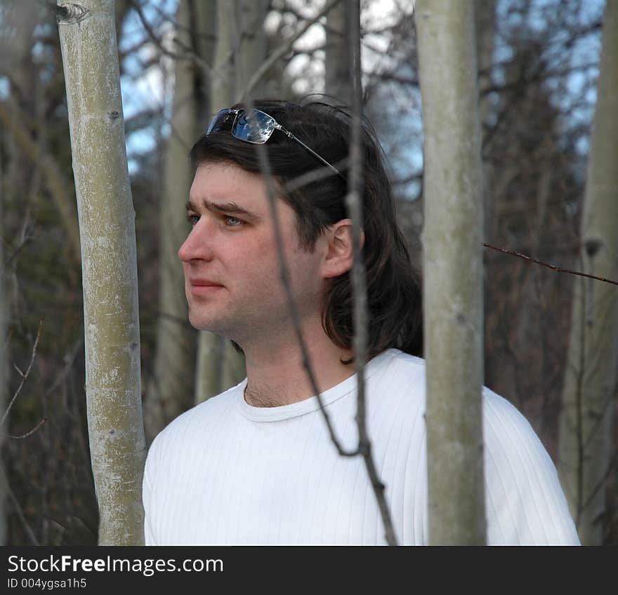 Man standing in midle of forest , in white shirt and sunglasses on his head. Man standing in midle of forest , in white shirt and sunglasses on his head