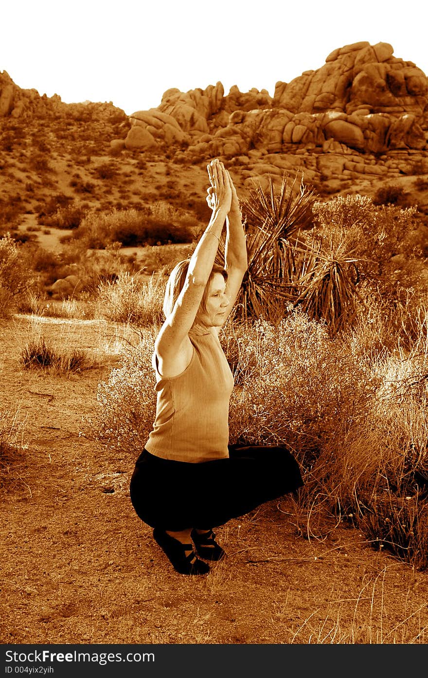 Senior woman practicing yoga at dusk in the desert. Senior woman practicing yoga at dusk in the desert.