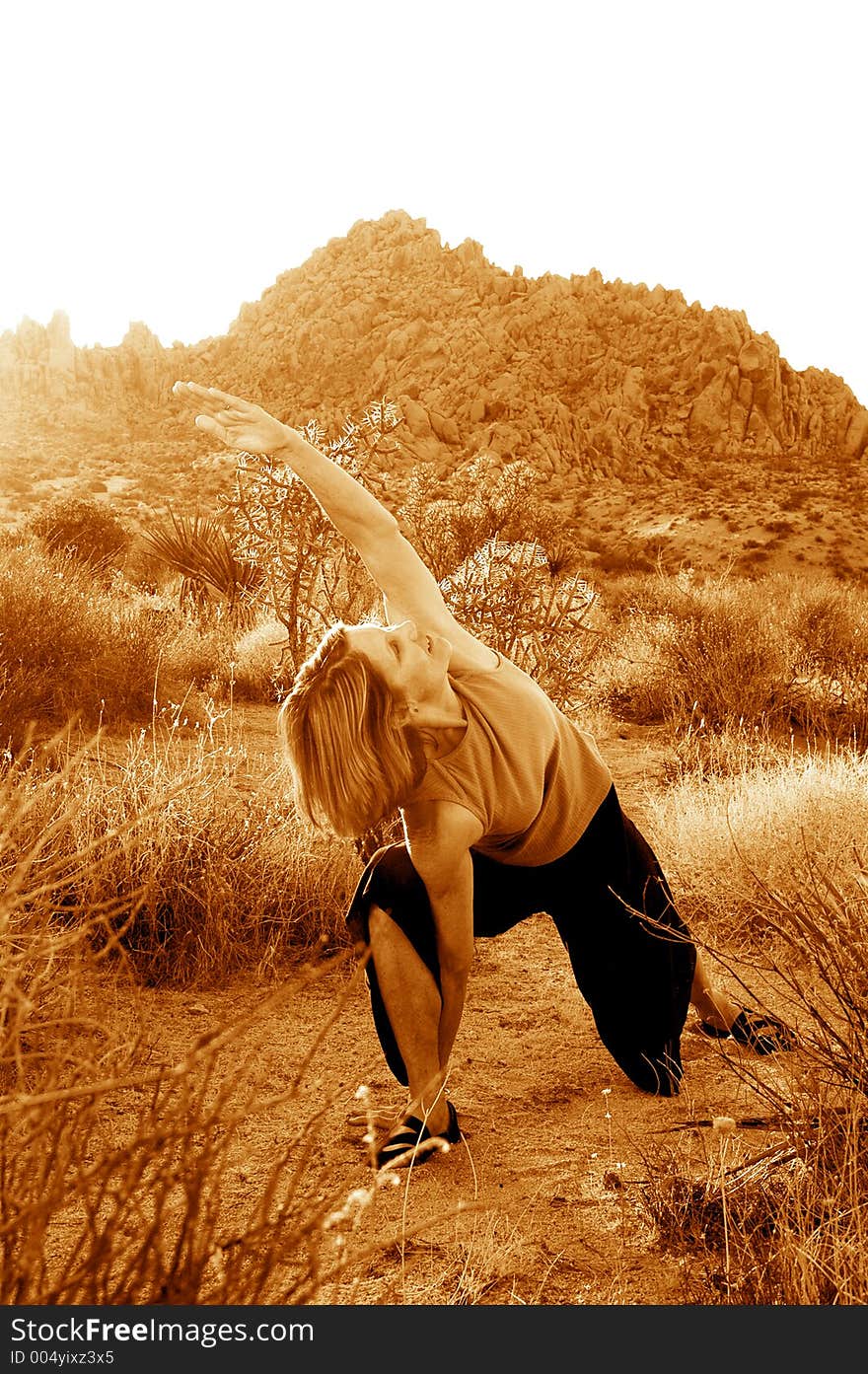 Senior woman practicing yoga during dusk in the desert. Senior woman practicing yoga during dusk in the desert.