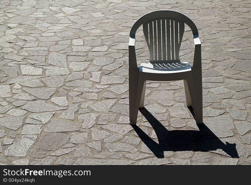 Single chair on stone pavement