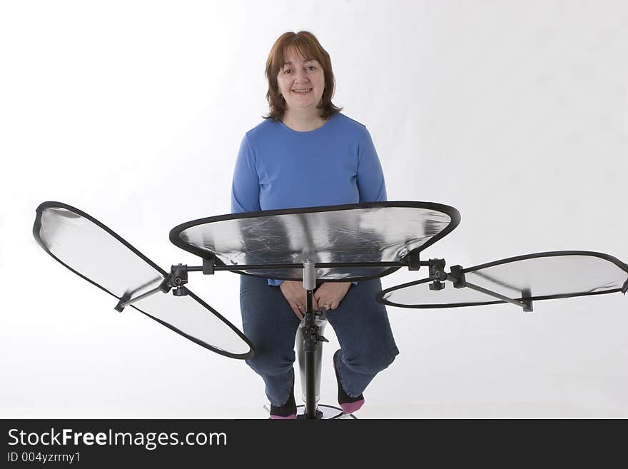 Model in front of reflectors in studio set up against white backdrop. Model in front of reflectors in studio set up against white backdrop