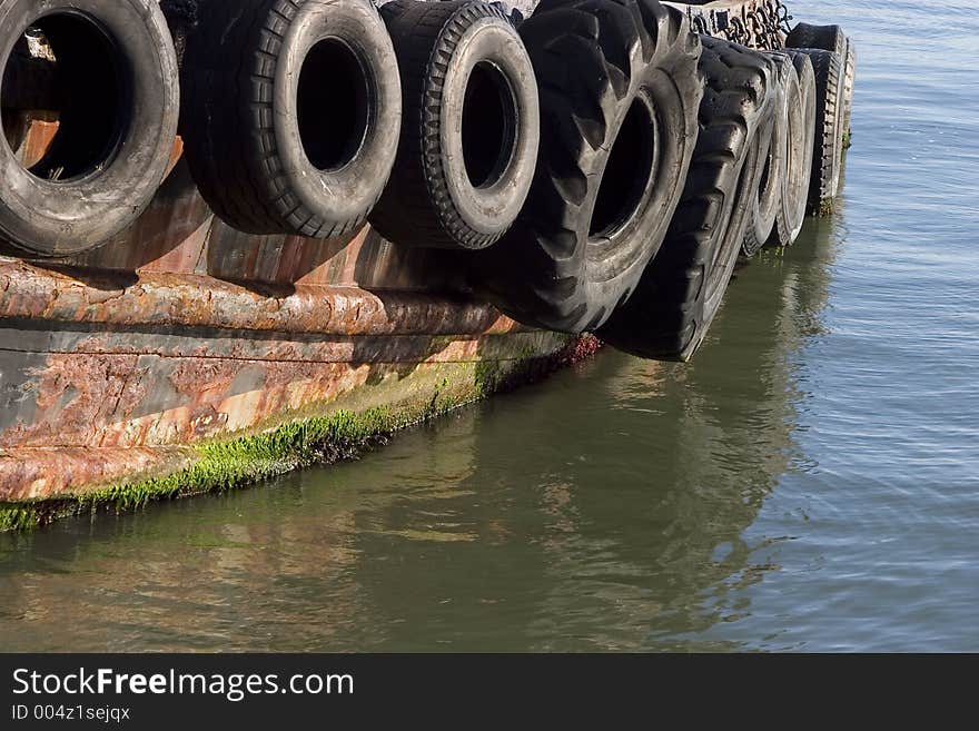 Old tires serve as bumpers for a tug boat. Old tires serve as bumpers for a tug boat.