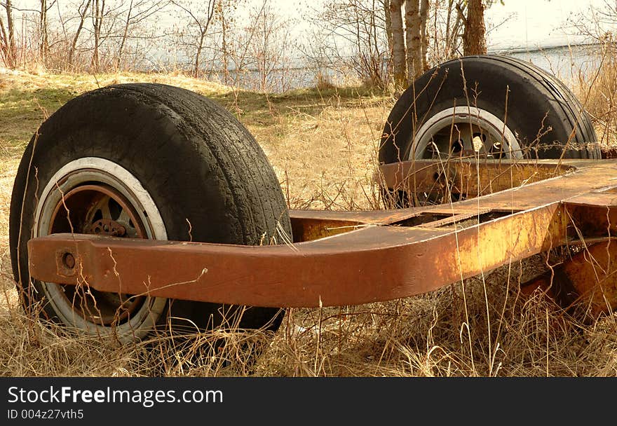 Old machinery part with two wheels abandoned in a park, in rural