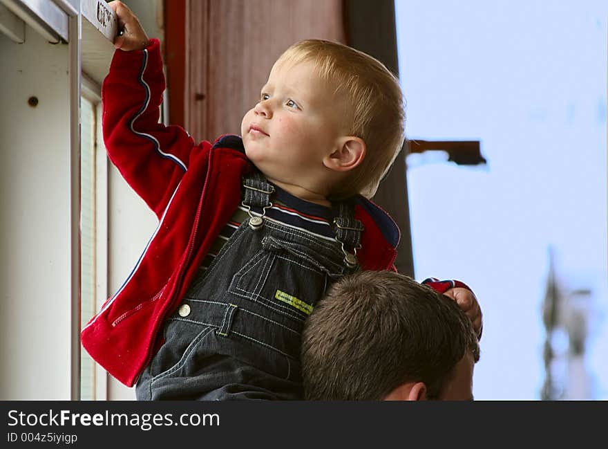 Two year old boy siting on his dad`s neck.