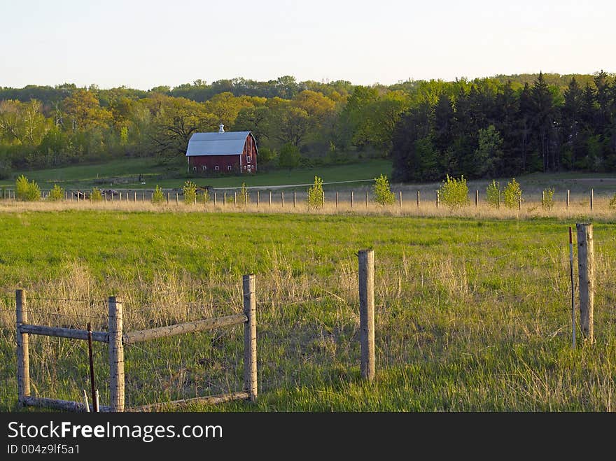 Fence with Red Barn and Farmland in Background