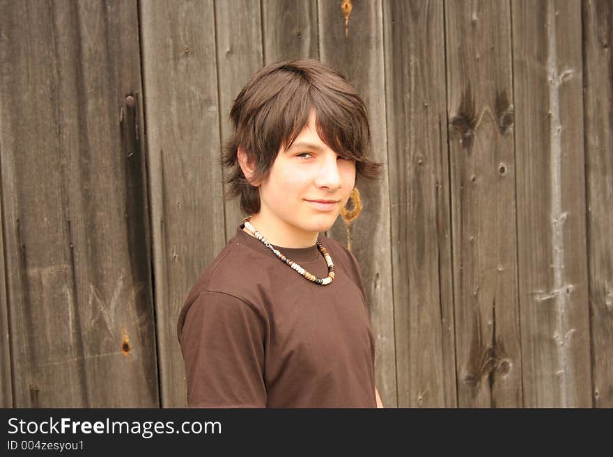 Young boy in front of a wooden wall. Young boy in front of a wooden wall