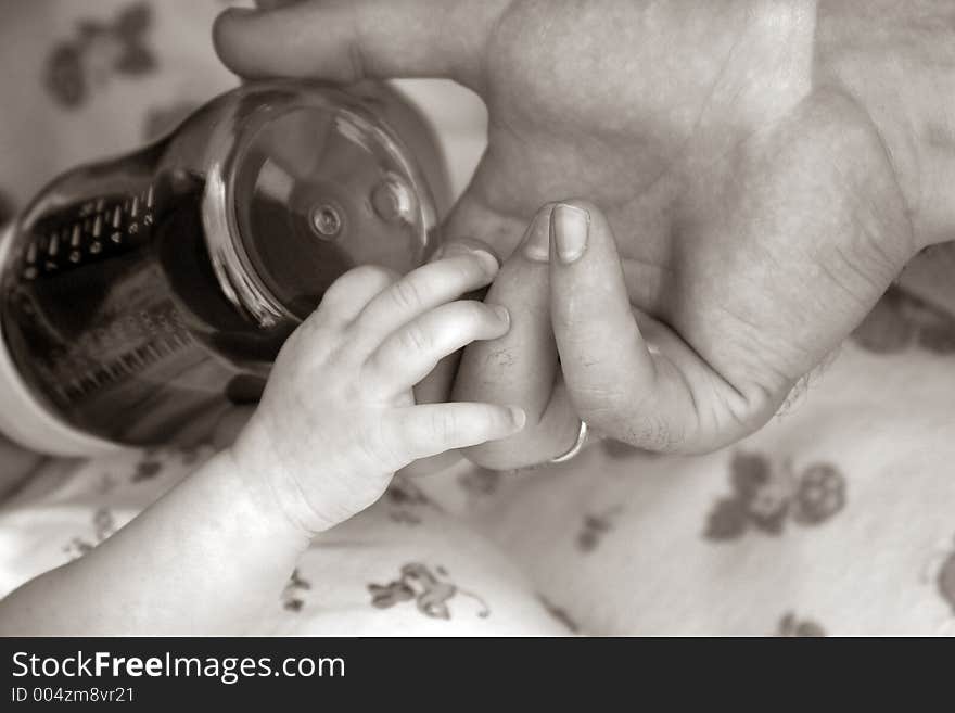 Hand of the kid and the parent. b/w + sepia. Hand of the kid and the parent. b/w + sepia.