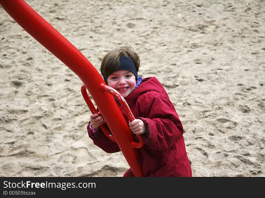 Child on a seesaw going up and down. the seesaw has four arms and the photographer was sitting on one of them - also going up and down. Child on a seesaw going up and down. the seesaw has four arms and the photographer was sitting on one of them - also going up and down.