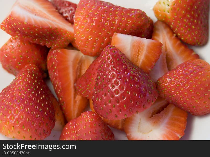 White ceramic bowl filled with fresh sliced strawberries. White ceramic bowl filled with fresh sliced strawberries.