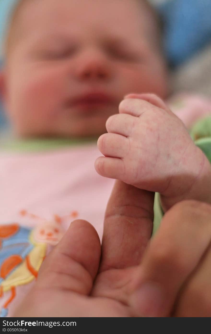 Baby hand on her father's finger