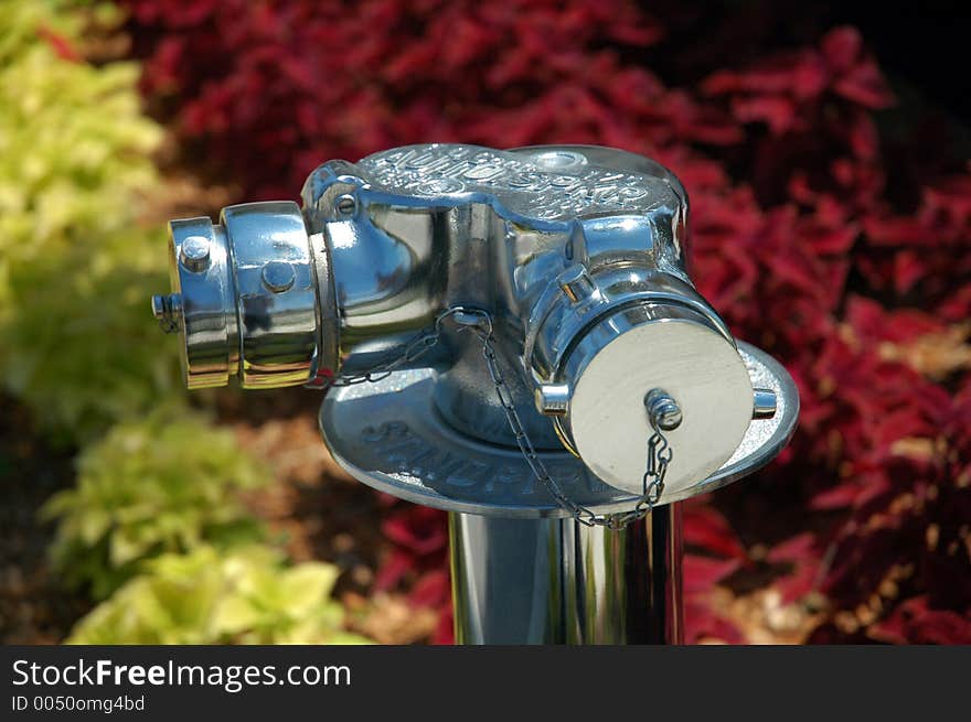 A chrome plated standpipe, against a green and purple background. A chrome plated standpipe, against a green and purple background.