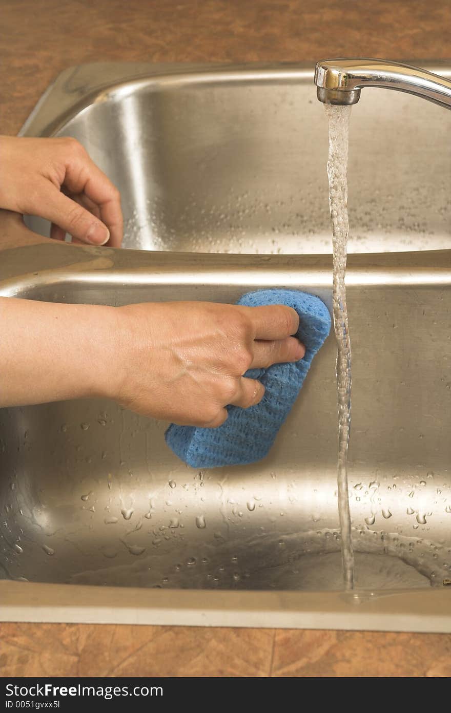 Washing the sink with blue sponge