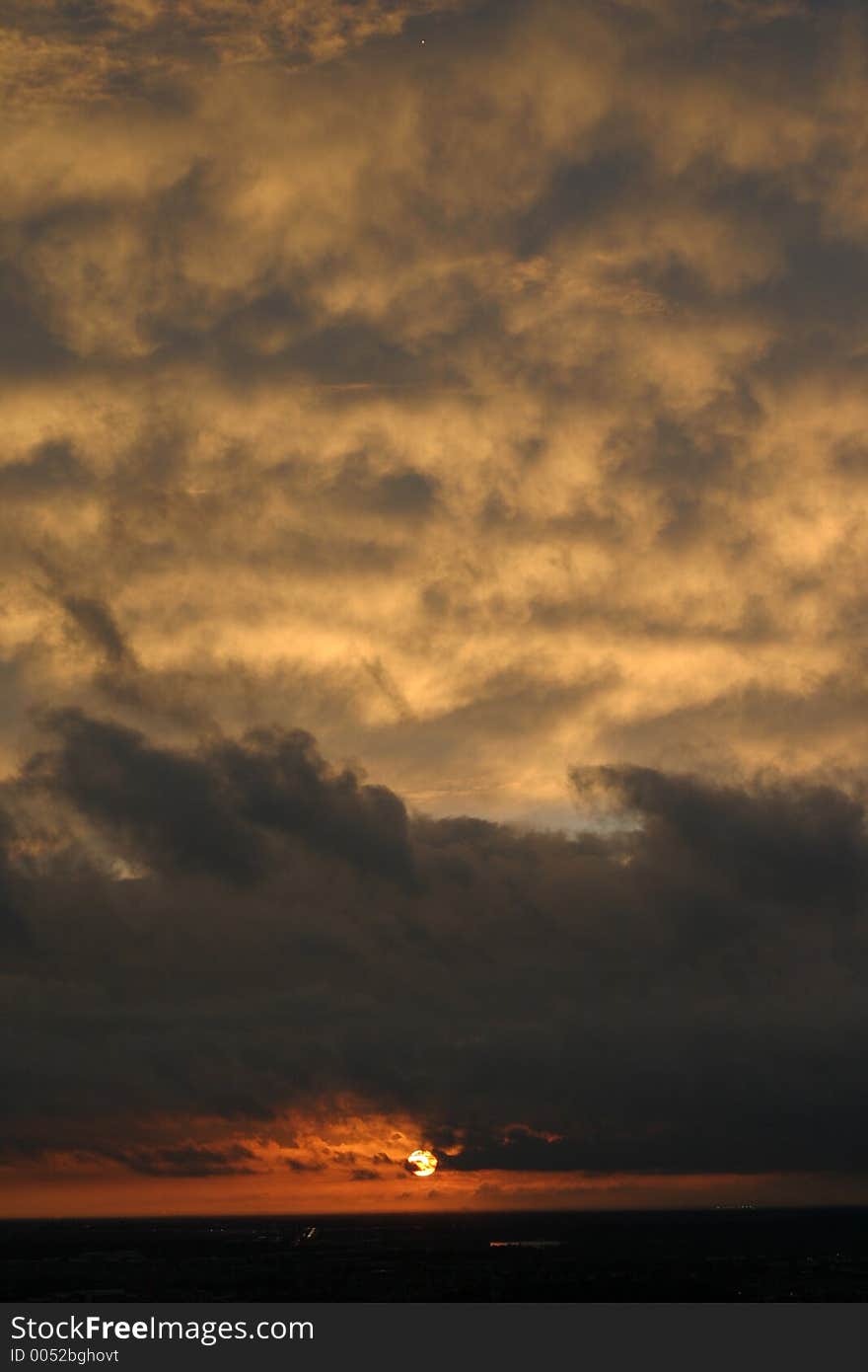 Sun setting behind the clouds.