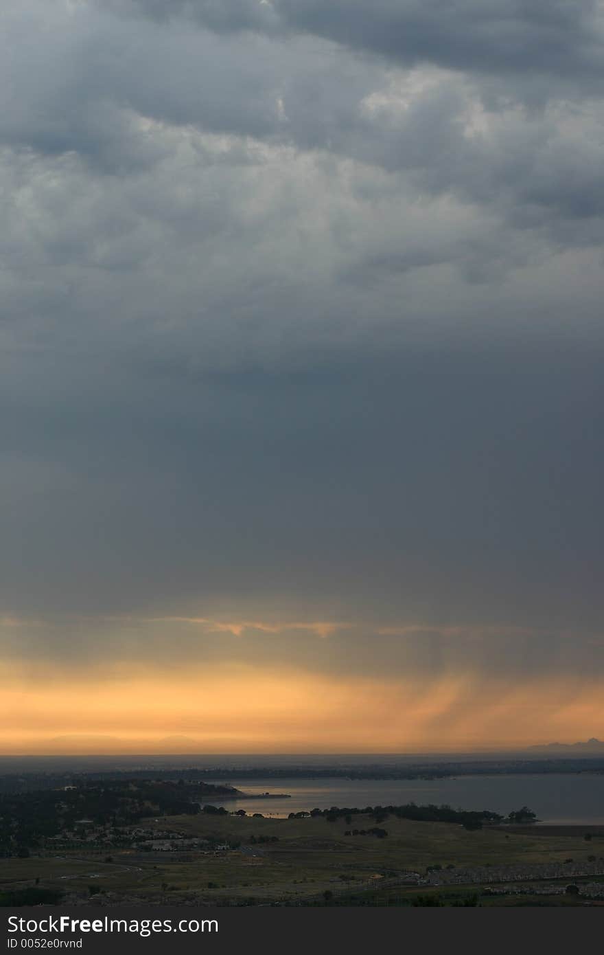 Rain in the distance with the sun fading over a lake. Rain in the distance with the sun fading over a lake.